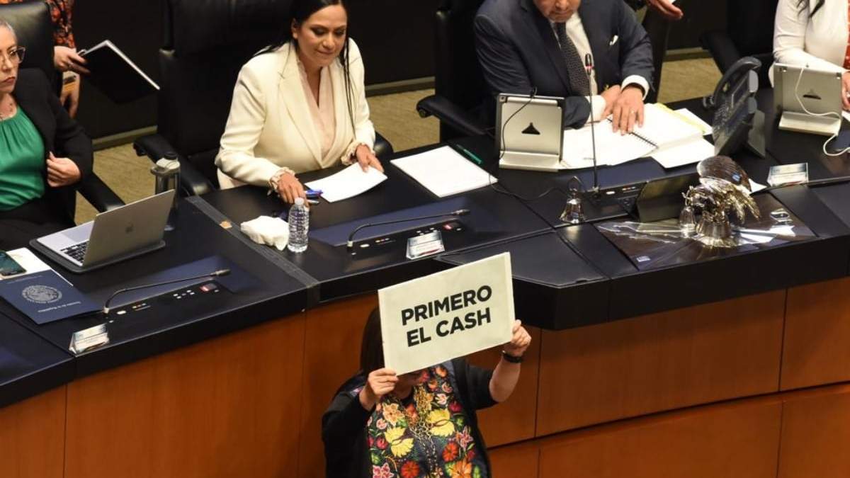 Xochitl Gálvez sostiene un cartel frente a Ariadna Montiel, secretaria de Bienestar