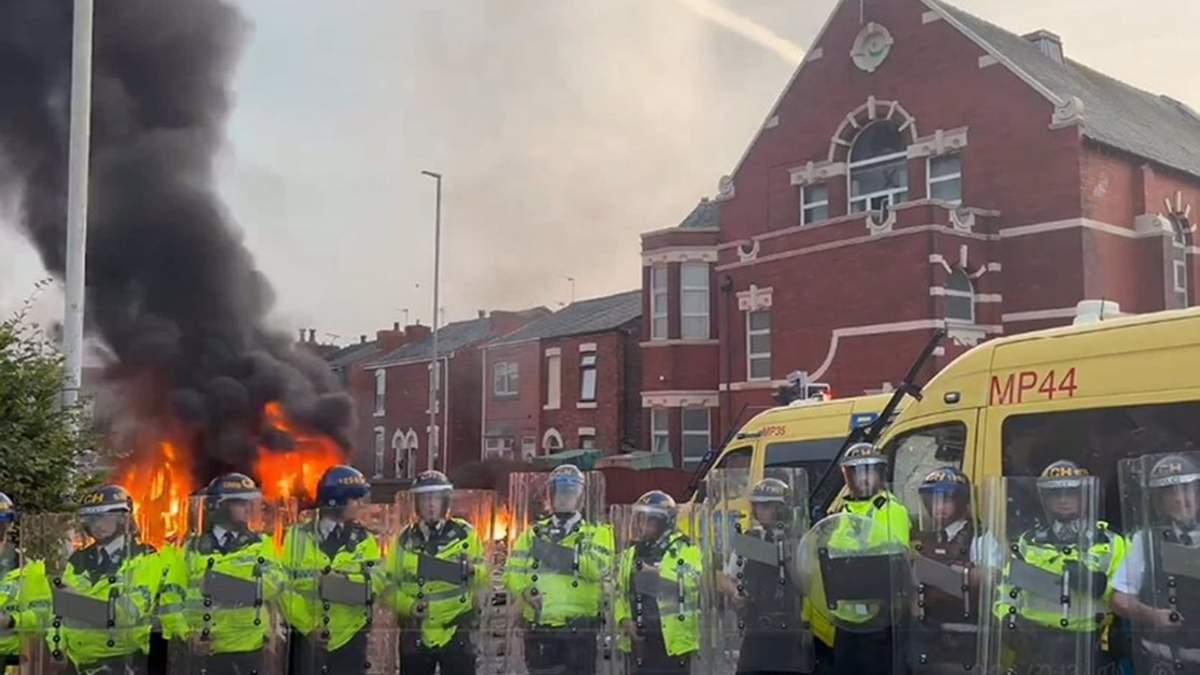 Furgón policial en llamas en la localidad británica de Southport en medio de protestas violentas por la muerte de tres menores víctimas de un apuñalamiento múltiple