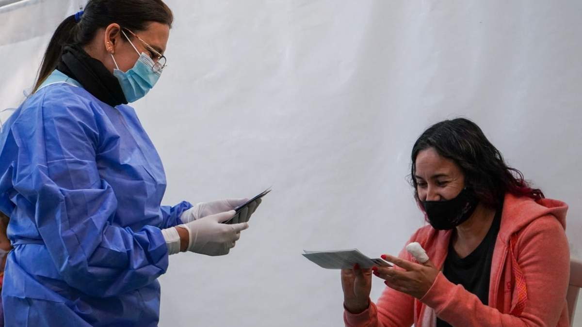 Profesional de la Salud entrega un certificado de vacunación. Fuente: (Twitter)