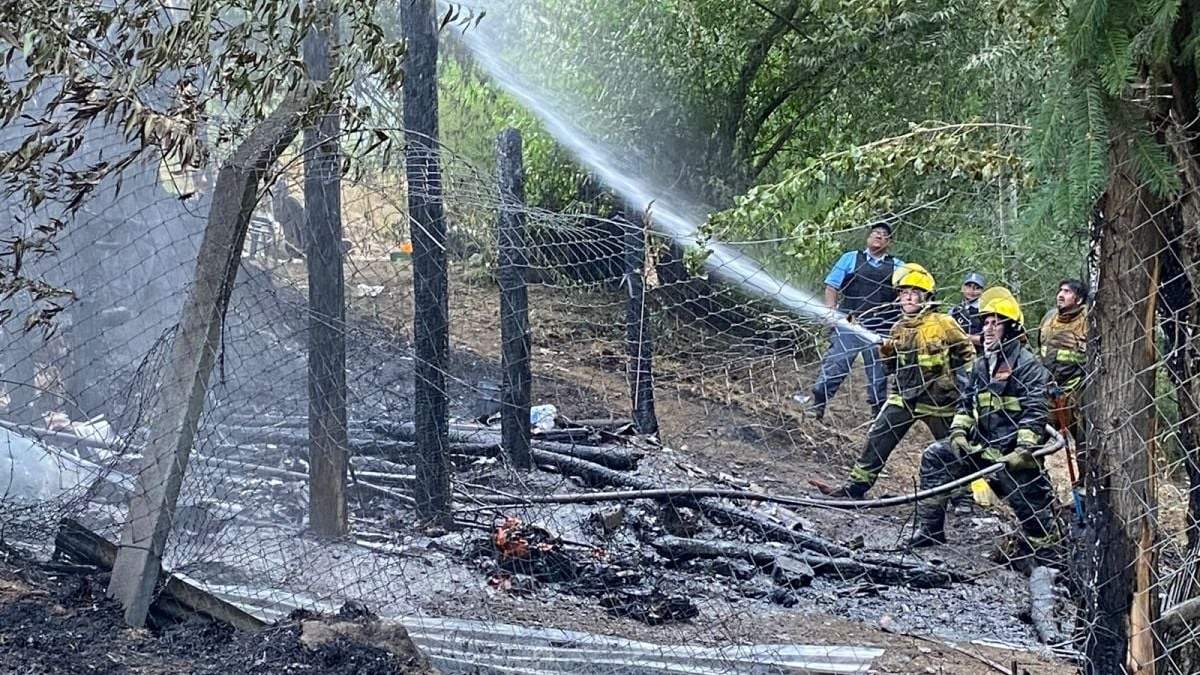 Personal de bomberos controlan los restos de la casa afectada por el incendio. Fuente: (FM de La Montaña).