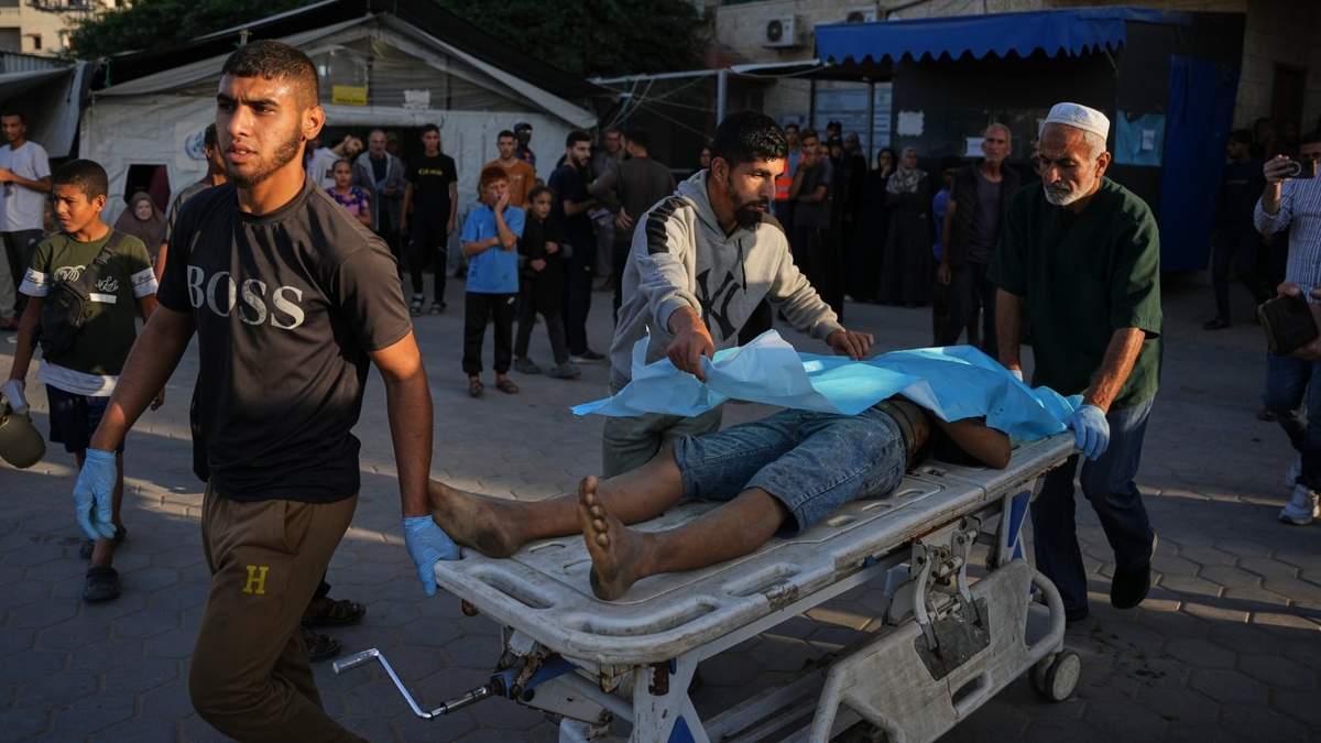 Palestinos trasladan el cuerpo de un hombre que murió por ataques israelíes en la Franja de Gaza a la morgue del Hospital Al-Aqsa en Deir al-Balah