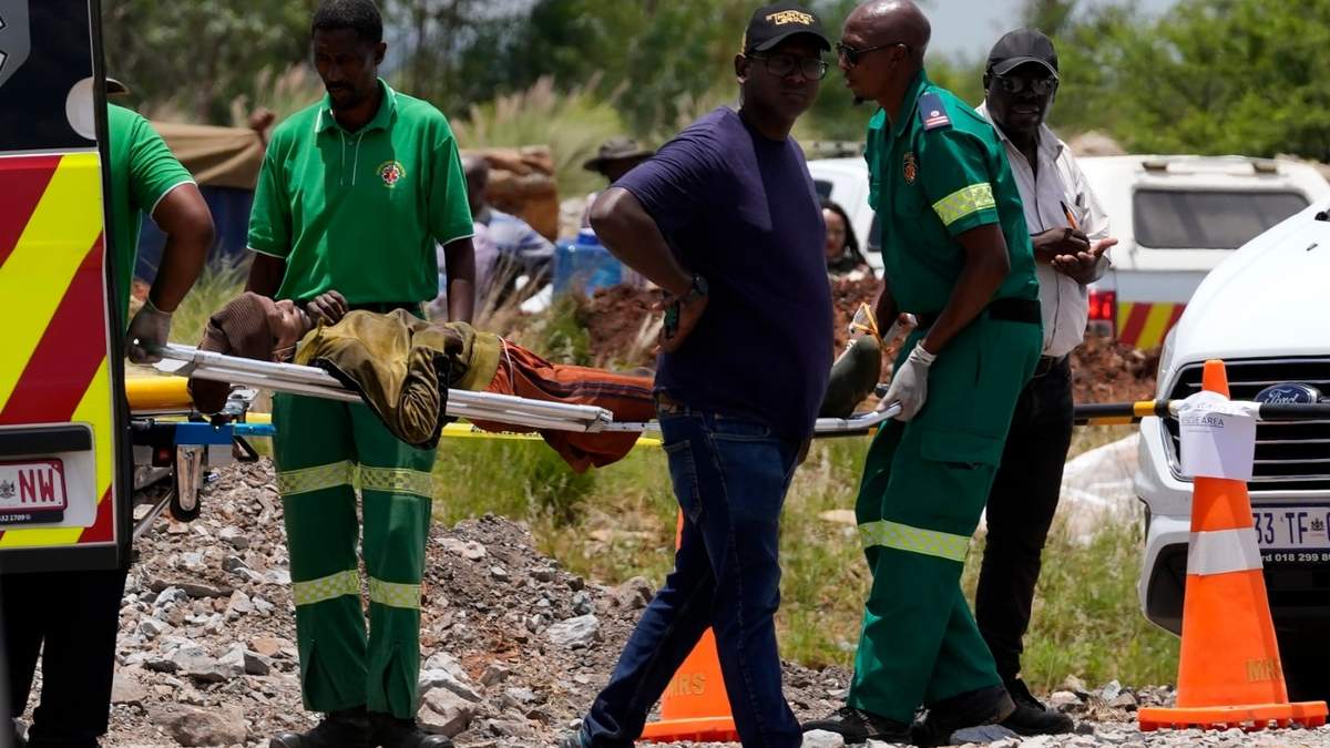 Rescatistas transportan a un minero sobre una camilla después de que fue rescatado de una mina de oro abandonada, el martes 14 de enero de 2025, en Stilfontein, Sudáfrica
