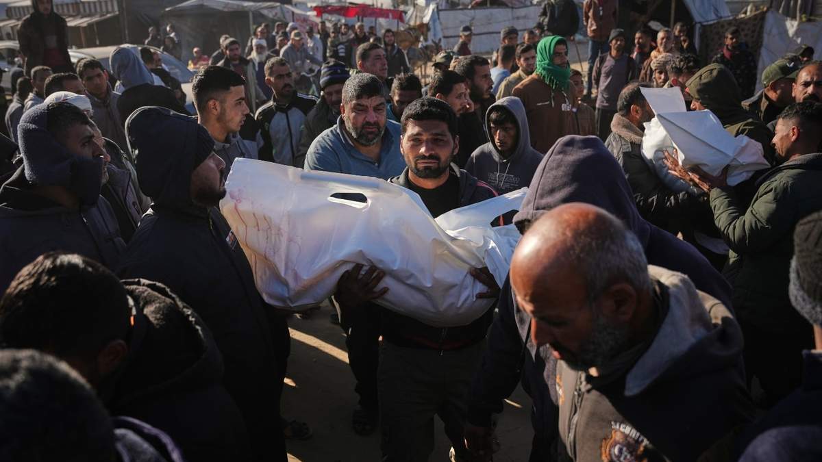 Un palestino carga con el cadáver de Sham Abu Hadaiyd, que murió en un ataque israelí contra un asentamiento de tiendas de campaña en Jan Yunis, Gaza