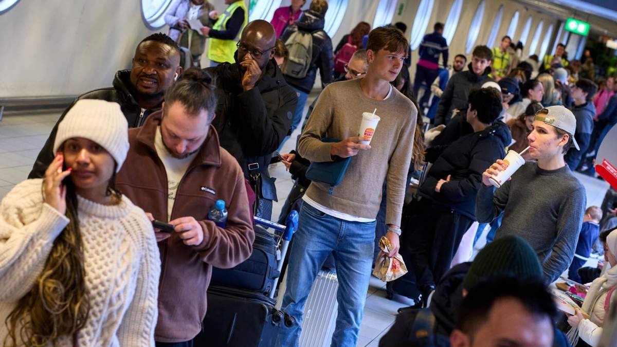 Viajeros varados forman una fila en la mesa de información del aeropuerto Schiphol en Ámsterdam, Holanda
