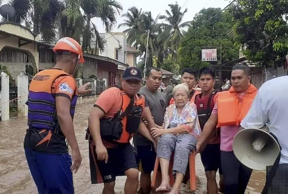 Una anciana es transportada sobre una silla por personal del servicio de guardacostas en medio de una inundación, el 26 de diciembre de 2022, en Plaridel, sur de las Filipinas