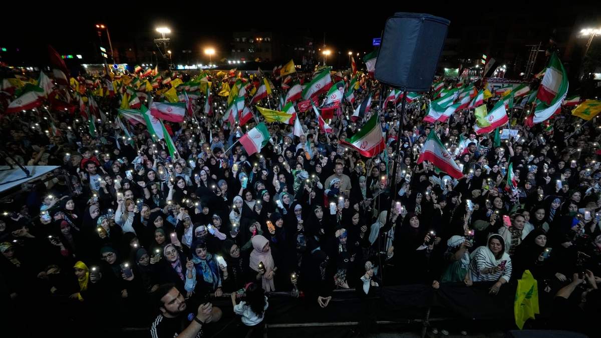 Manifestantes ondean banderas iraníes y del grupo político y militar libanés Hezbollah durante una reunión del progobierno en la plaza de la Revolución Islámica en Teherán, Irán, el sábado 30 de mayo de 2026