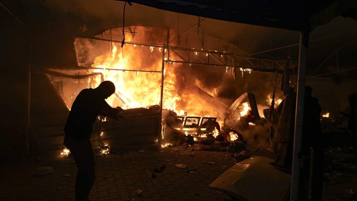 Palestinos reaccionan a un incendio después de que un ataque israelí golpeara una zona de tiendas en el patio del Hospital Mártires de Al Aqsa en Deir al Balah, Franja de Gaza