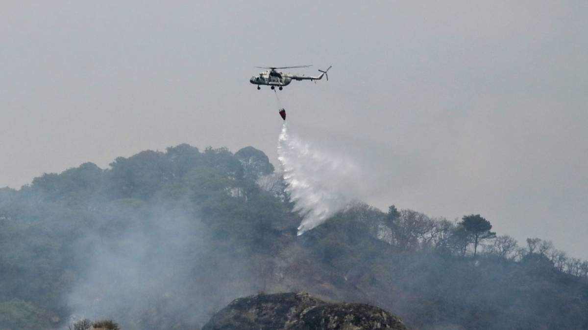 Un helicóptero derrama agua sobre el incendio en Tepoztlán