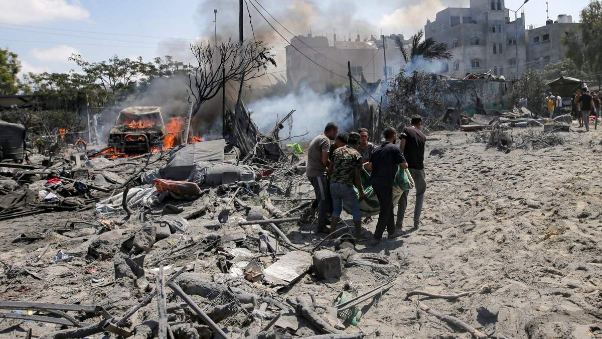 Los palestinos evacuan un cuerpo de un lugar afectado por un bombardeo israelí en Khan Younis
