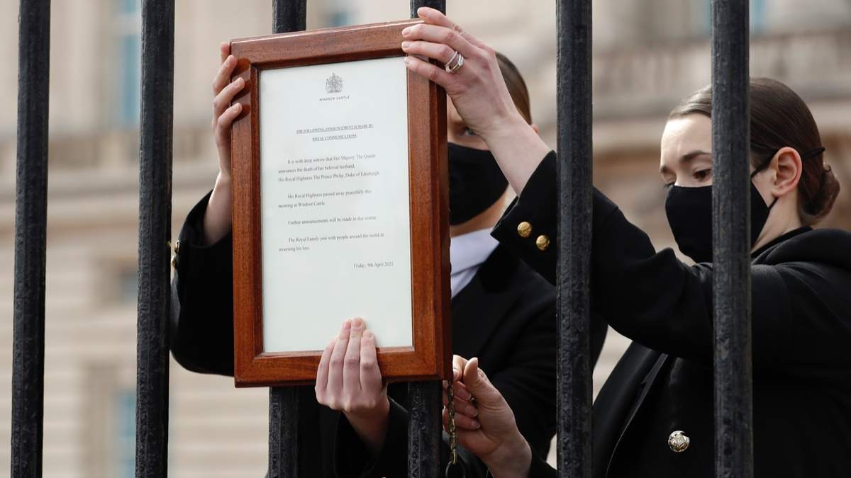 Personal del Palacio de Buckingham coloca un anuncio oficial de la muerte del príncipe Felipe en la entrada, en Londres