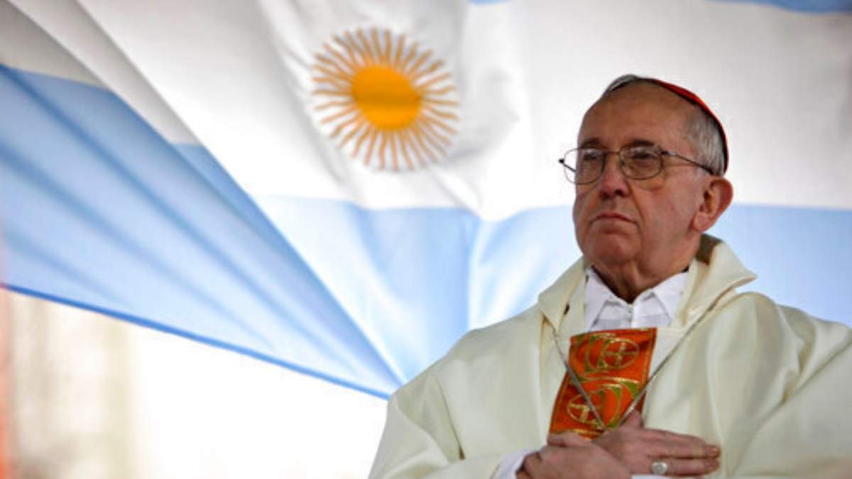 El cardenal argentino Jorge Bergoglio oficia una misa afuera de la iglesia de San Cayetano con una bandera de Argentina detrás, en Buenos Aires, Argentina, el viernes 7 de agosto de 2009