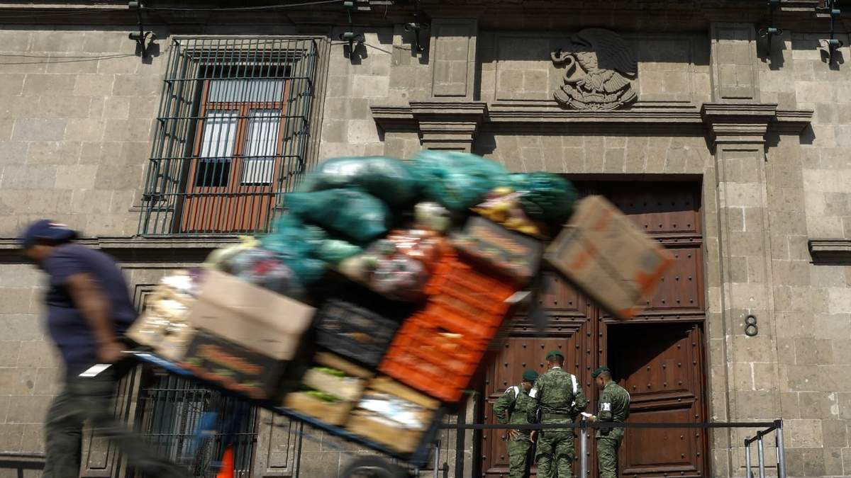 Un hombre tira un carrito lleno de mercancías frente al Palacio Nacional en la Ciudad de México, el 5 de diciembre de 2019