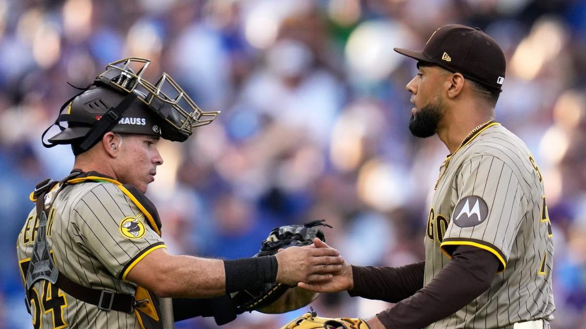El relevista Robert Suárez y el receptor Freddy Fermín de los Padres de San Diego celebran la victoria