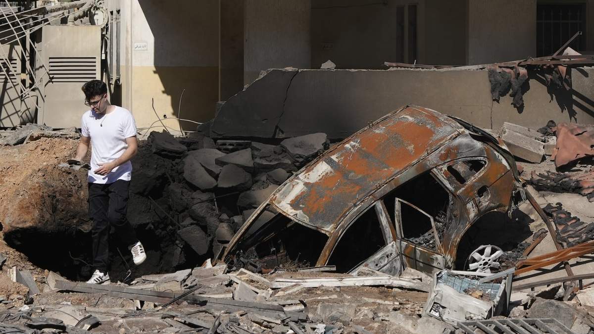 Un hombre camina sobre escombros en el lugar donde se produjo un ataque aéreo israelí
