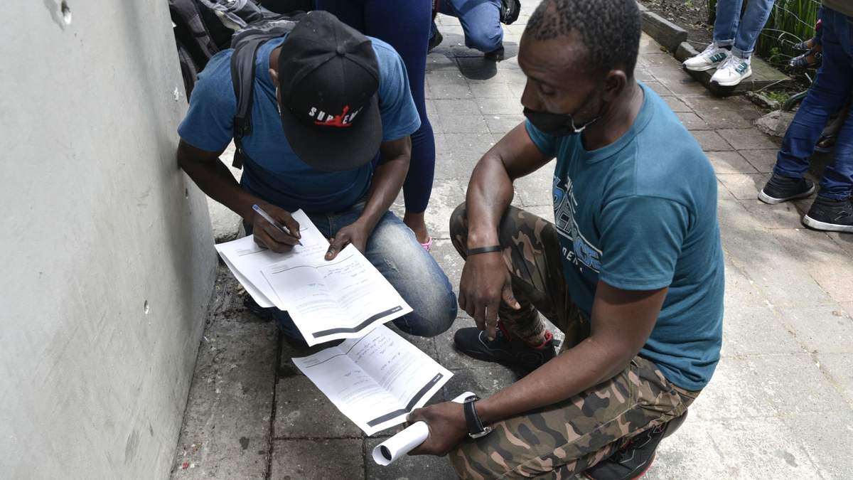 Migrantes llenan su solicitud de asilo en México