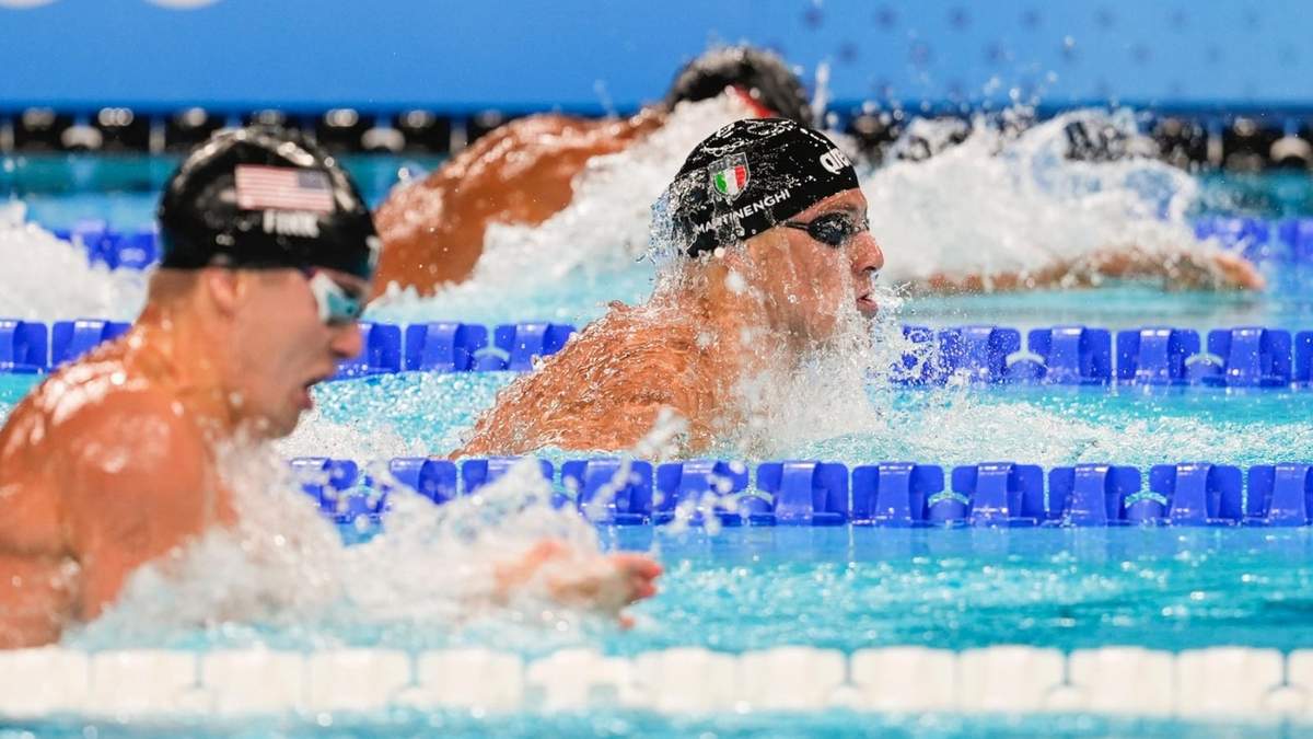 El italiano Nicolo Martinenghi (centro) compite en la final de 100 metros pecho en los Juegos Olímpicos
