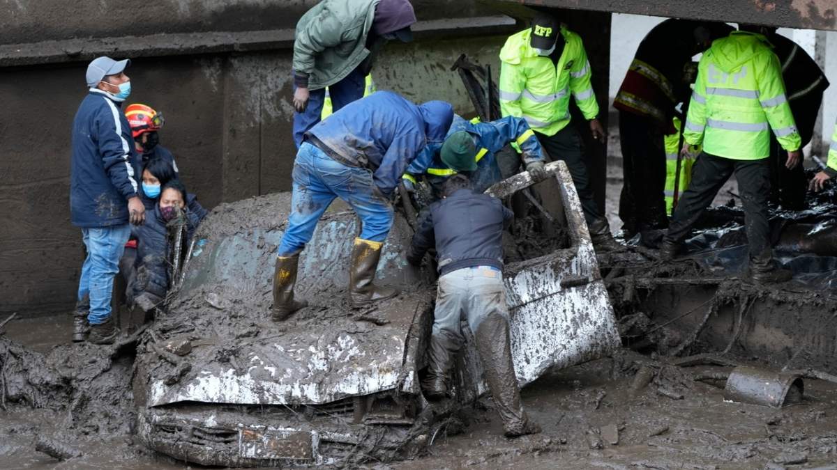 Elementos de emergencias buscan sobrevivientes en un auto arrastrado por la avalancha