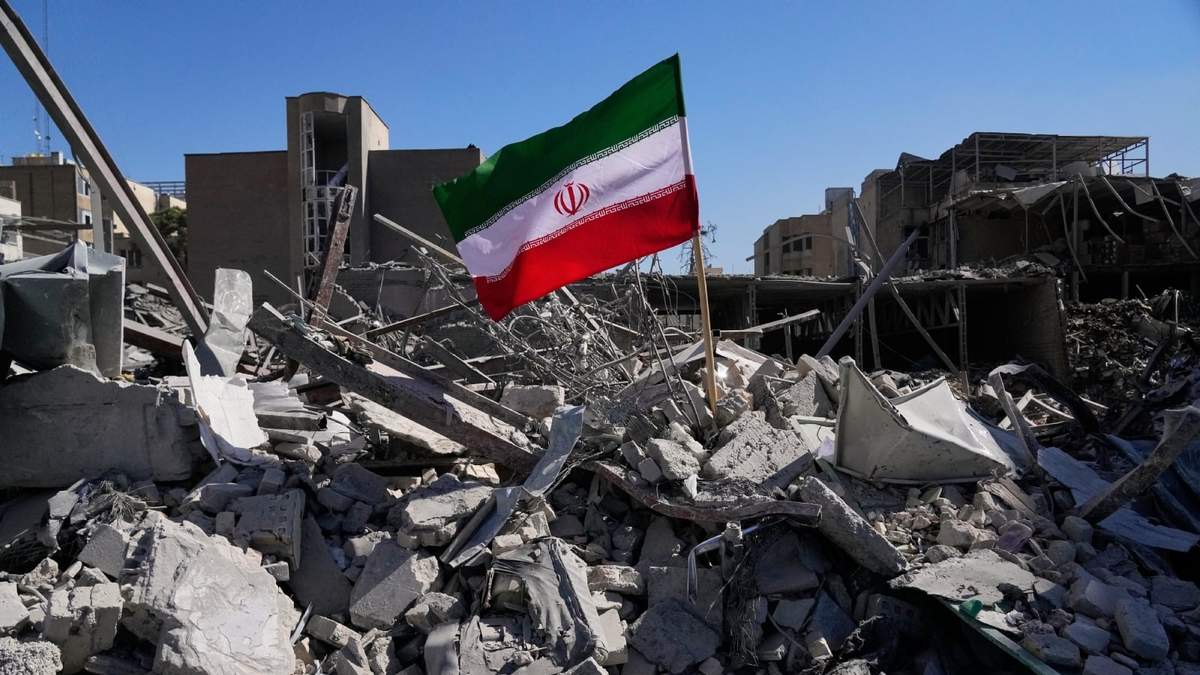 Una bandera iraní se ve entre las ruinas tras bombardeos de EU e Israel