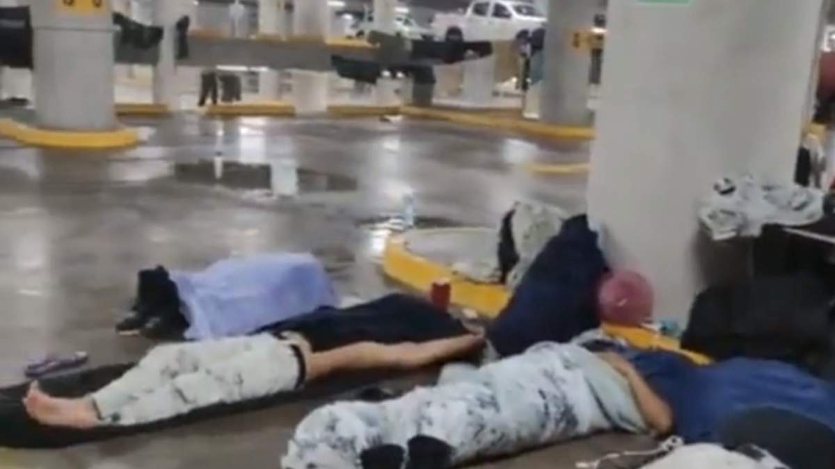 Elementos de la Guardia Nacional descansan en colchonetas cerca de goteras