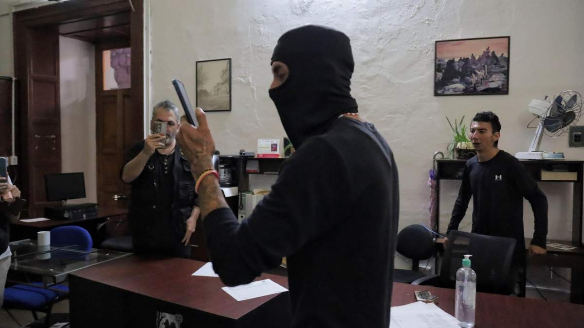 Hombres y mujeres vestidos de negro se mezclaron con el grupo e ingresaron por la fuerza al recinto
