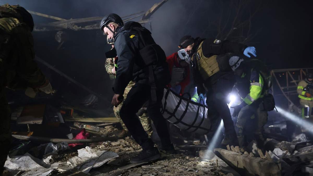Agentes de policía trasladan el cuerpo de una persona fallecida en un ataque con drones rusos en un vecindario residencial de Zaporiyia, Ucrania