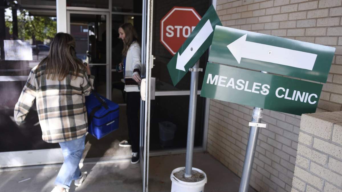 Miembros del personal del Departamento de Salud del condado de Andrews llevan dosis de la vacuna contra el sarampión, las paperas y la rubeola, el martes 8 de abril de 2025, en Andrews, Texas