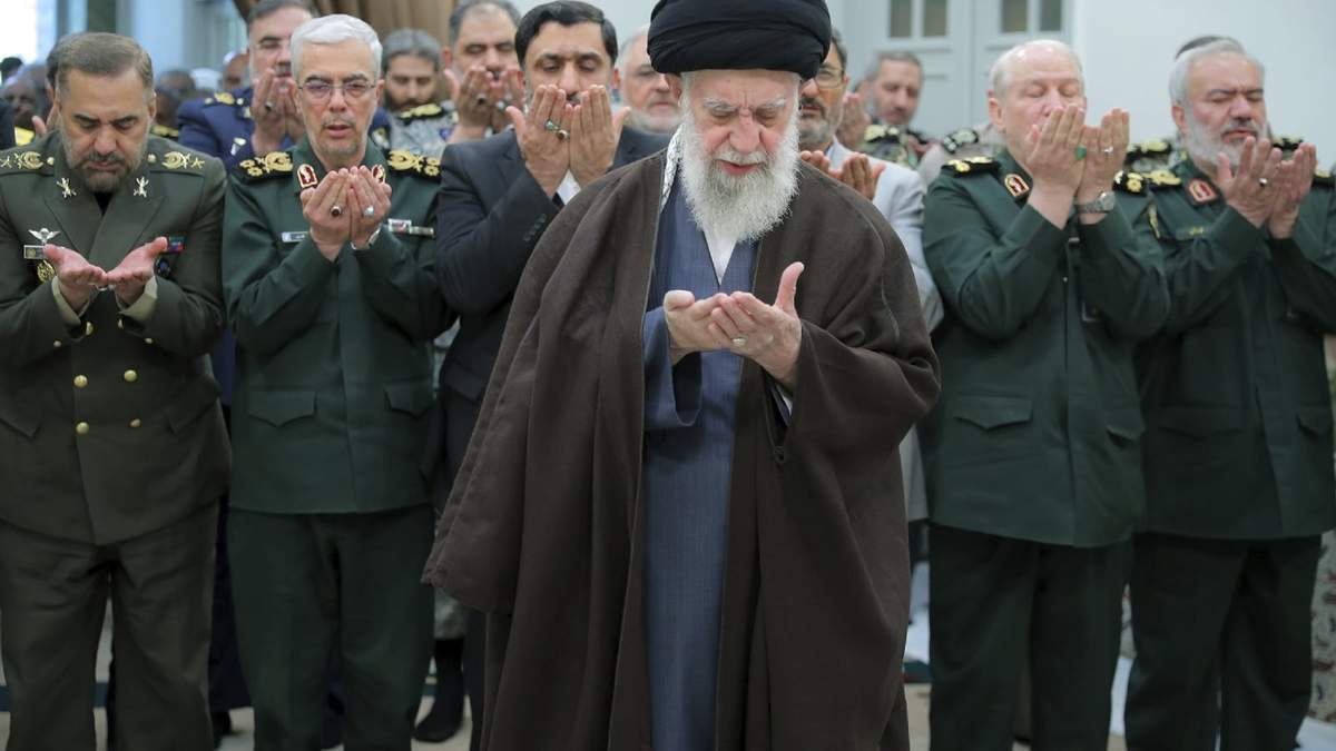 En una fotografía difundida por el sitio oficial de la oficina del máximo líder religioso de Irán, el ayatolá Alí Jamenei, centro, ofrece una oración durante una reunión con jefes militares en Teherán, Irán