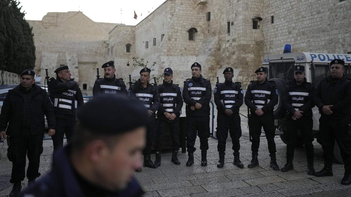 La policía palestina hace cola junto a la Iglesia de la Natividad, tradicionalmente considerada el lugar de nacimiento de Jesús, en la Víspera de Navidad, en la ciudad cisjordana de Belén, el martes 24 de diciembre de 2024