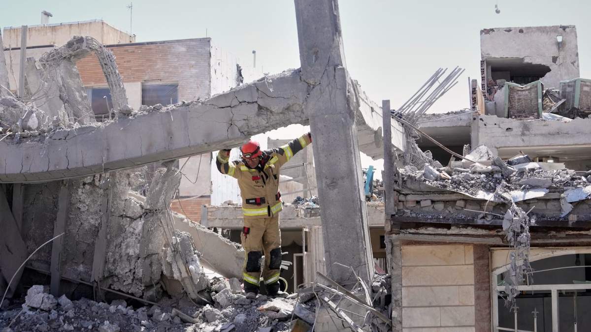 Un rescatista examina los daños en la estructura de un edificio alcanzado por un ataque israelí-estadounidense en Teherán