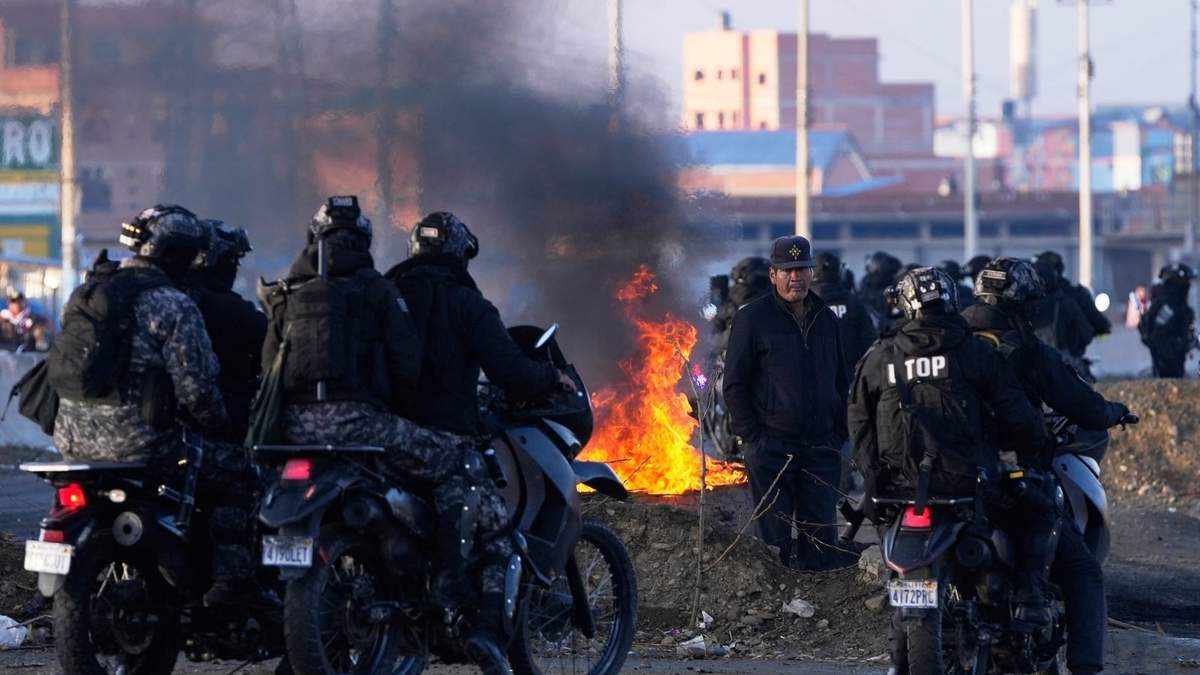 Motociclistas aguardan cerca de las barricadas levantadas por manifestantes antigubernamentales en una carretera en El Alto, Bolivia