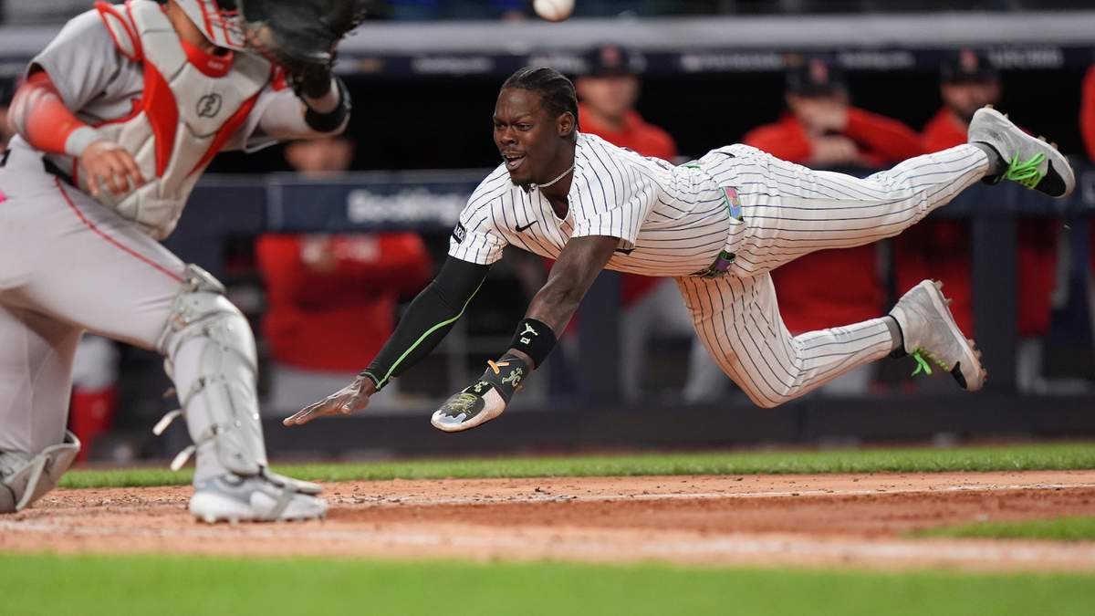 Jazz Chisholm Jr. de los Yankees de Nueva York se arroja en el plato para anotar una carrera ante los Medias Rojas de Boston en el segundo juego de la serie de comodines