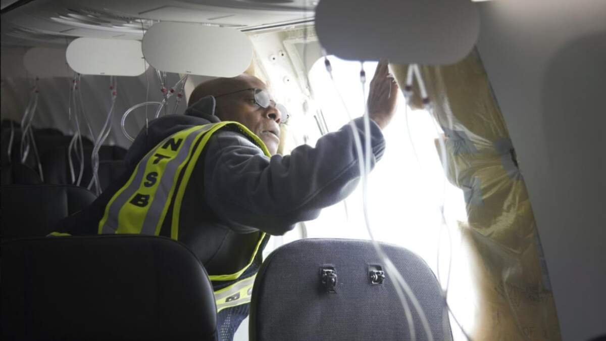 El investigador jefe de la agencia, John Lovell, examina la zona donde se desprendió un panel en el vuelo 1282 de Alaska Airlines el domingo 7 de enero de 2024 en Portland, Oregon