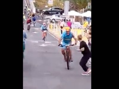 Ciclista arrolla en una carrera a una espectadora que cruzó distraída (Video)
