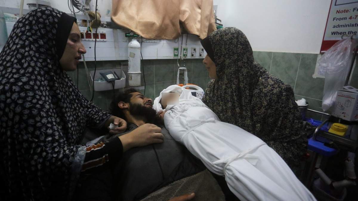 Una palestina muestra el cadáver de su nieta al padre de la beba luego de que murió a causa de un bombardeo israelí en la Franja de Gaza