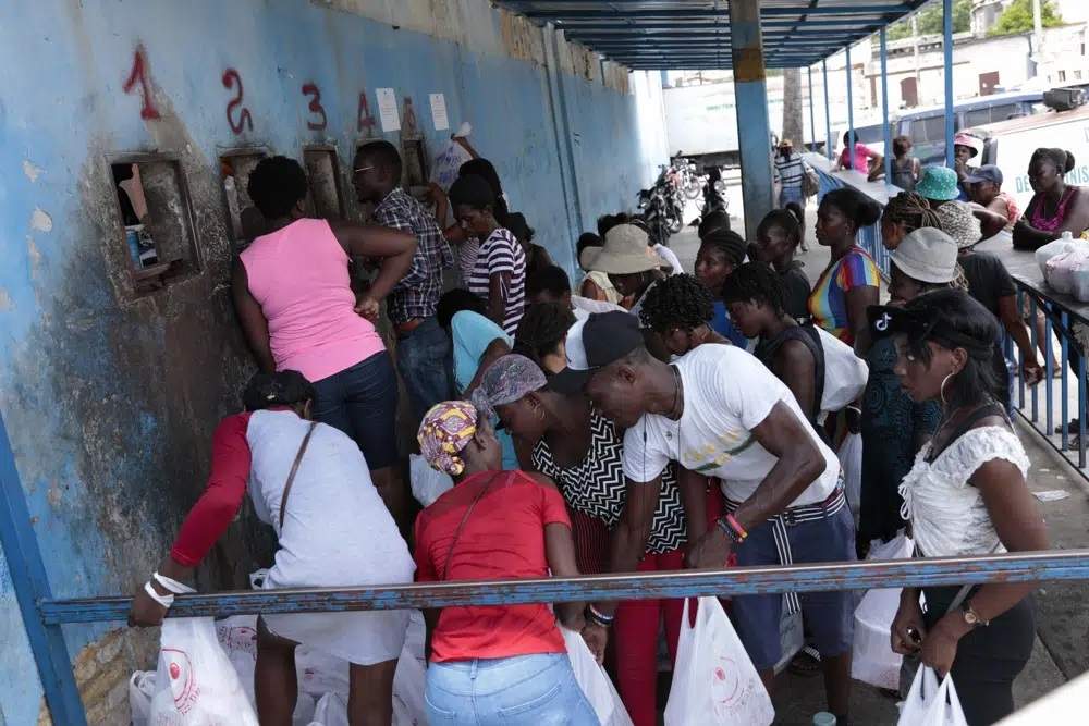 Decenas de personas aguardan su turno para entregar alimentos a sus familiares encarcelados en la Penitenciaría Nacional de Haití, en Puerto Príncipe, el 1 de junio de 2023