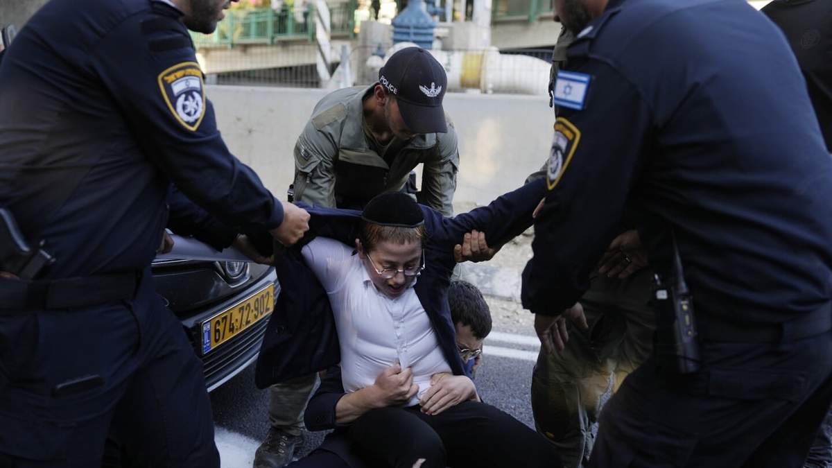 La policía israelí retira a jóvenes judíos ultraortodoxos que bloquean una carretera para protestar contra el reclutamiento militar en Bnei Brak, cerca de Tel Aviv, Israel