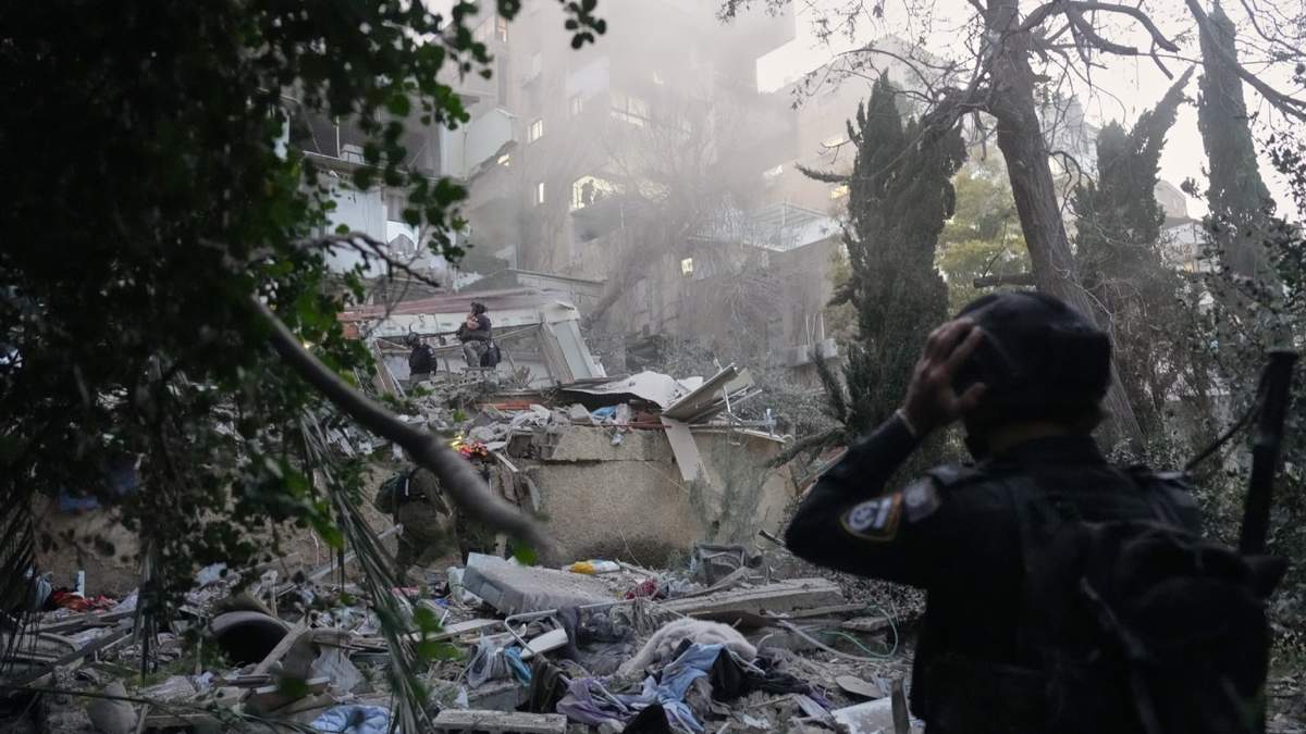Fuerzas de seguridad y equipos de rescate israelíes trabajan entre los escombros de un edificio residencial alcanzado por un misil iraní en Haifa, Israel, el domingo 5 de abril de 2026