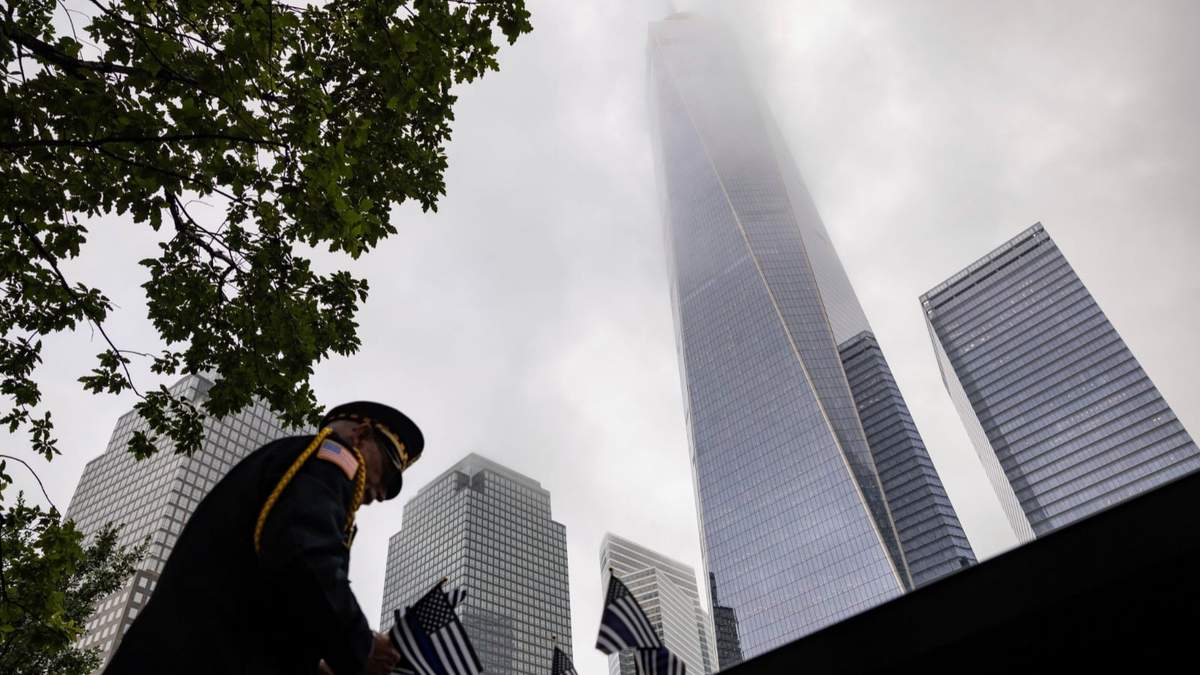 Un uniformado coloca banderas en Nueva York para los actos conmemorativos de los ataques terroristas de septiembre de 2001