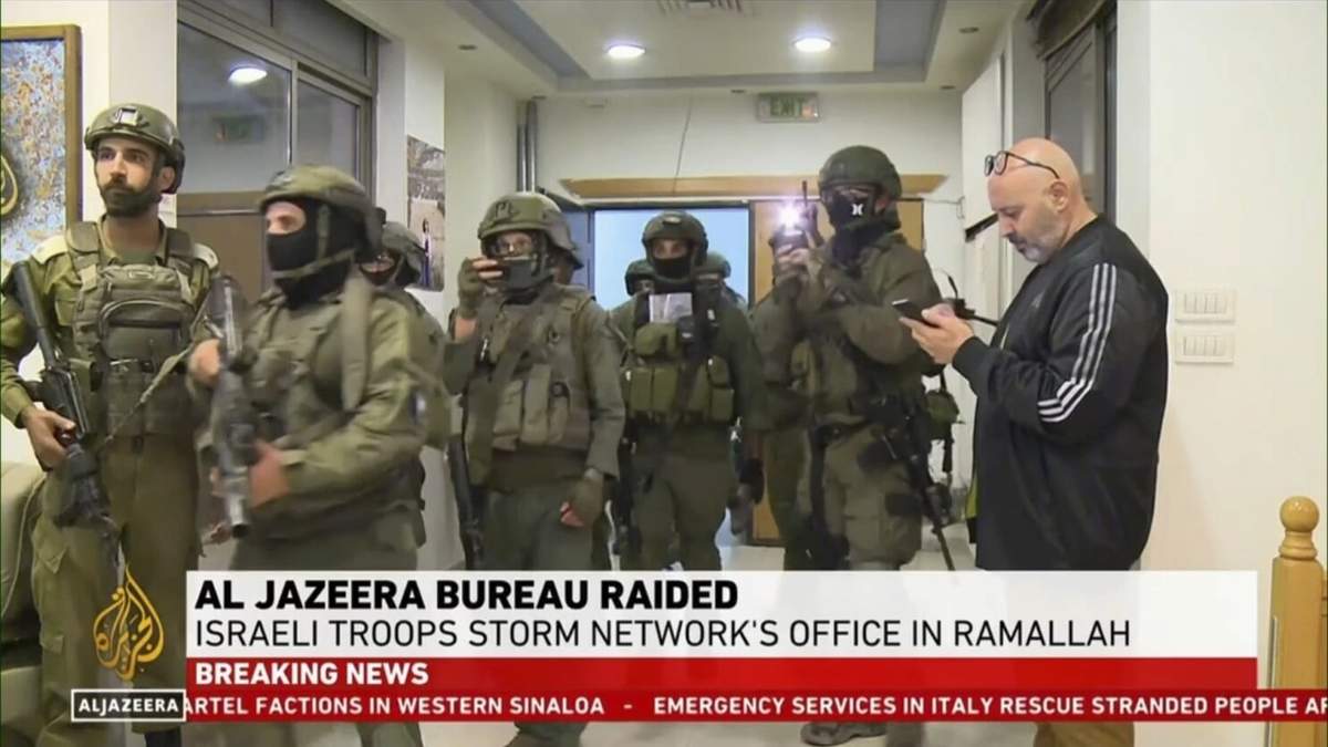 Esta imagen tomada de un video y proporcionada por Al Jazeera English muestra tropas israelíes allanando su oficina en Ramala, Cisjordania