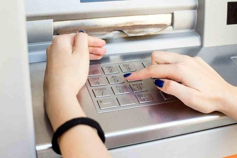 Una mujer realiza operaciones en un cajero automático