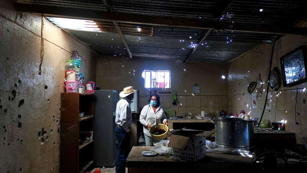 Un hombre y una mujer observan los daños en la cocina de su casa tras un enfrentamiento entre elementos del Ejército y un grupo armado en la comunidad de Sarabia, en la Sierra de Los Cardos de Jerez, Zacatecas