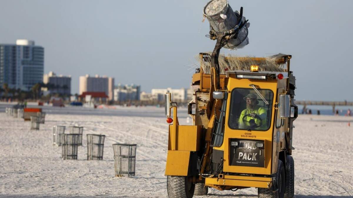 Un trabajador municipal vacía botes de basura en preparación para la llegada de una tormenta en Clearwater Beach, en Clearwater, Florida