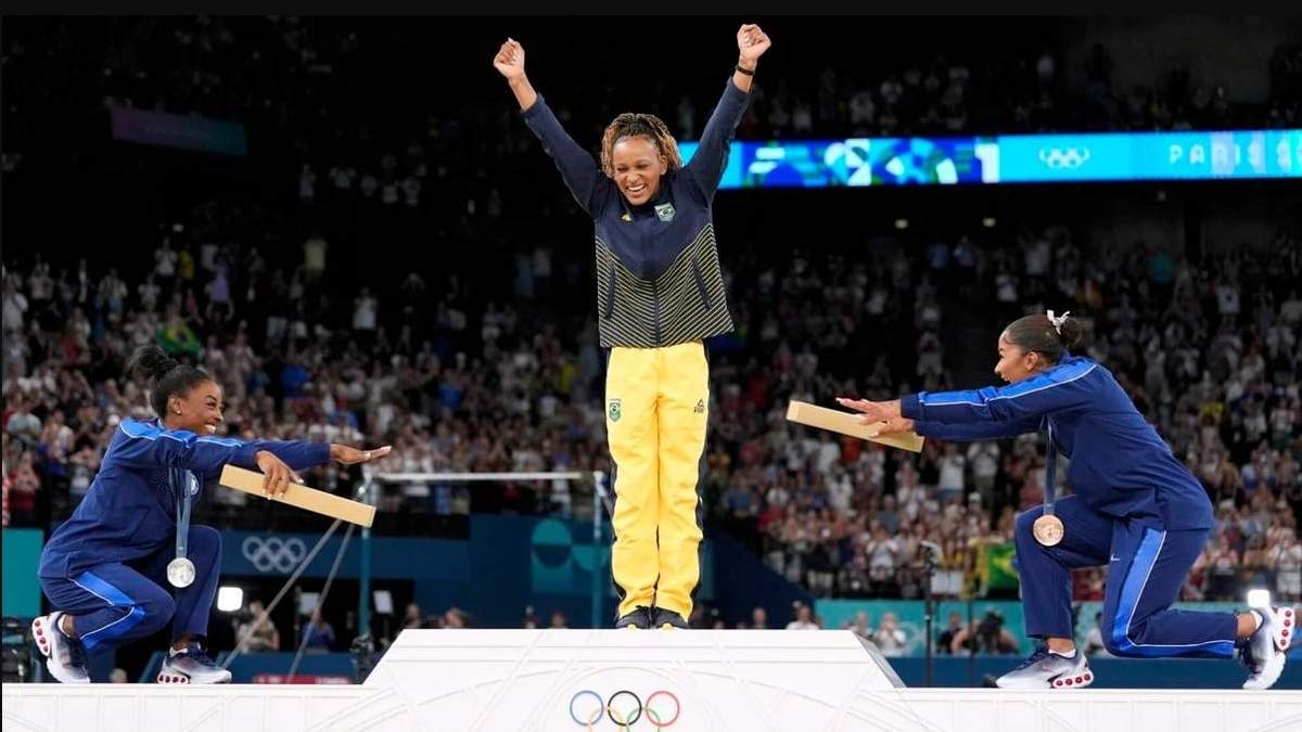 La medalllista de plata Simone Biles (izquierda) y la medallista de bronce Jordan Chiles se inclinan ante la campeona brasileña Rebeca Andrade tras ganar la medalla de oro en el ejercicio de piso de los Juegos Olímpicos de París