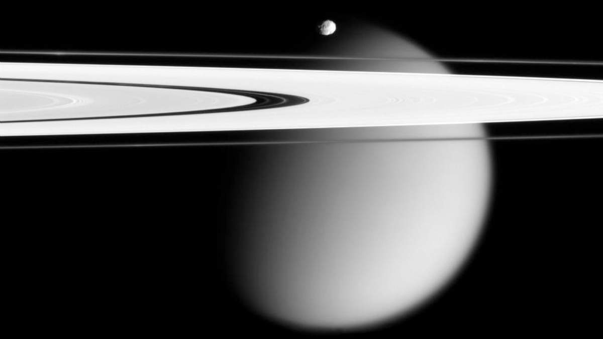 En la imagen, tomada por la nave espacial Cassini y proporcionada por la NASA el 12 de marzo de 2006, aparecen dos de las lunas de Saturno, la pequeña Epimeteo y Titán, envuelta en neblina, con los anillos A y F de Saturno extendiéndose