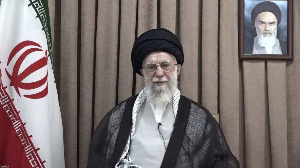 En la imagen, publicada el miércoles 18 de junio de 2025 por el sitio web oficial del líder supremo iraní, aparece el ayatolá Ali Jamenei en un discurso televisado, debajo de un retrato del fallecido fundador revolucionario, el ayatolá Jomeini