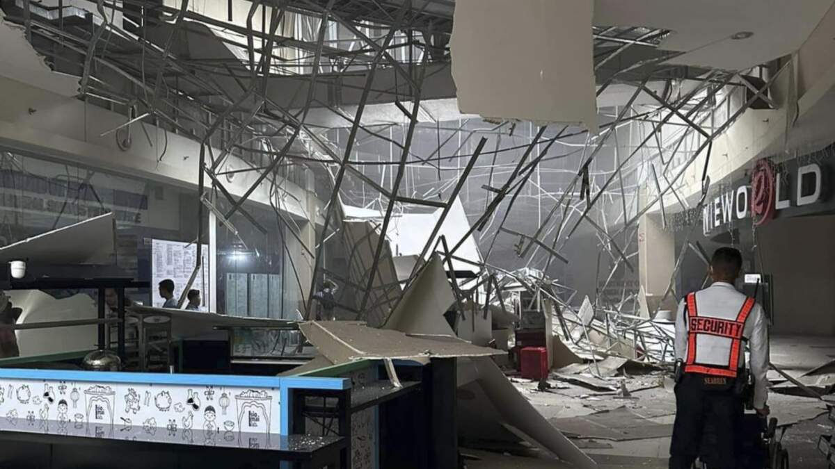 Un guardia de seguridad camina cerca del techo caído de un centro comercial tras un sismo en General Santos City, en el sur de Filipinas