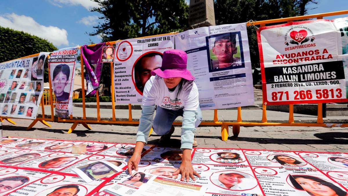 Una activista coloca fotos de desaparecidos durante una manifestación