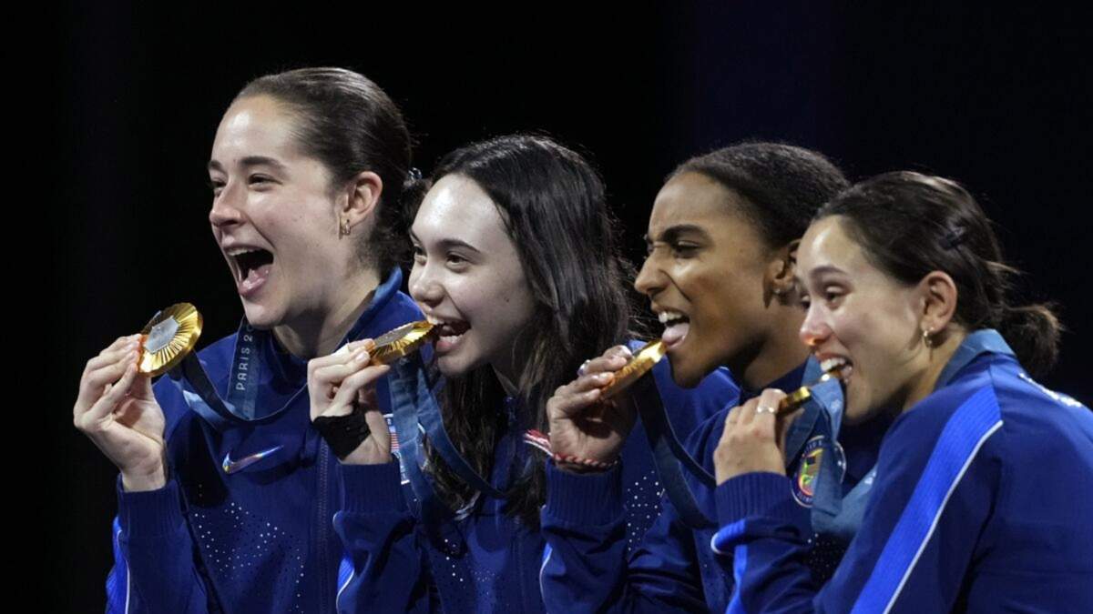 El equipo femenino estadunidense de esgrima compuesto por Lee Kiefer, Lauren Scruggs, Jaqueline Dubrovich y Maia mei Weintraub celebra en el podio al conquistar la medalla de oro
