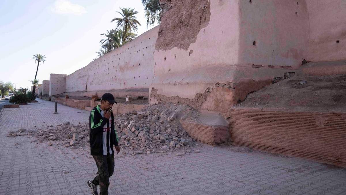Un hombre pasa junto a un tramo dañado de la muralla de la histórica Medina de Marrakech tras un potente sismo