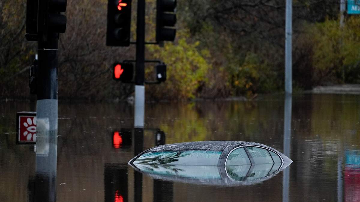 Un carro sobre un camino inundado después de una tormenta en San Diego